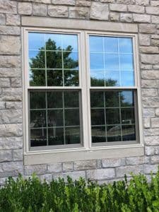 Gorgeous double-hung windows on a home with stone siding.